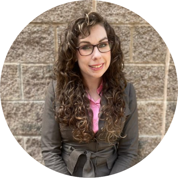 A woman with long curly hair wearing glasses.