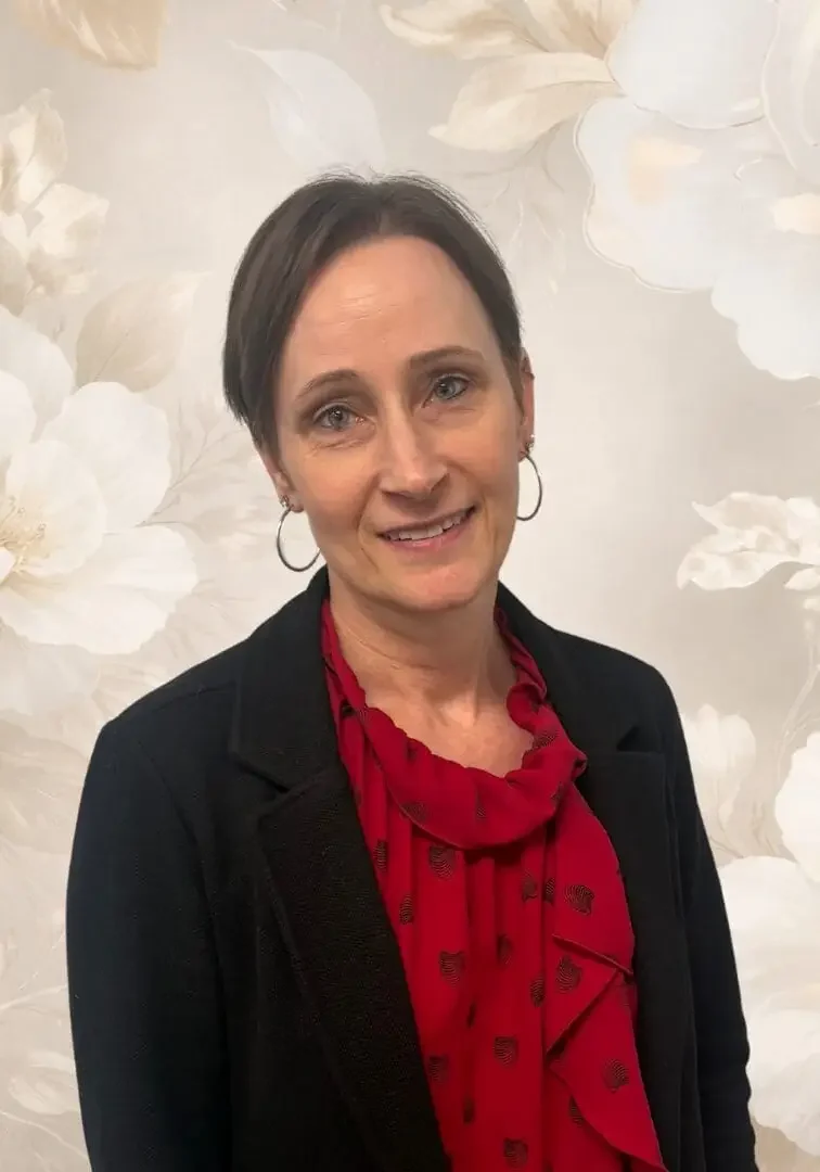 Woman in red blouse, floral background.