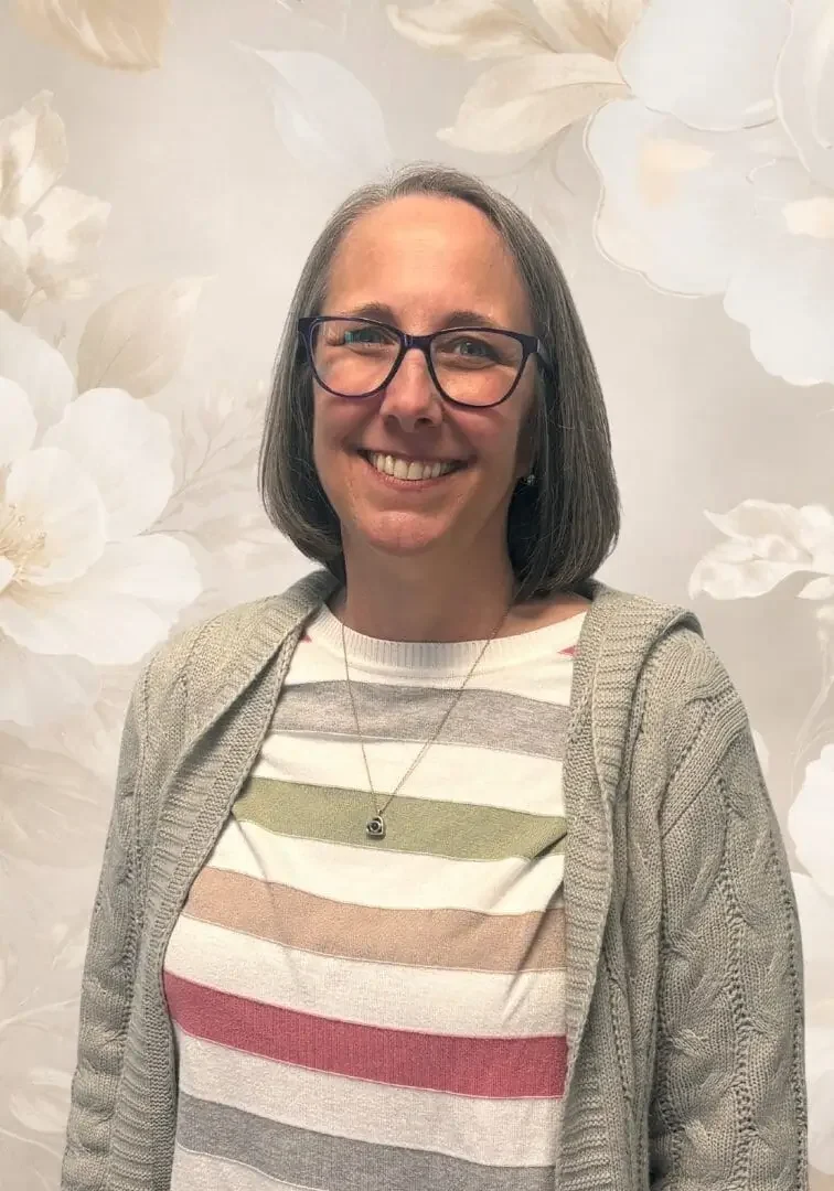 Smiling woman with floral background.